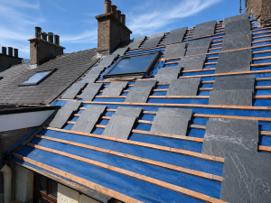 Slate roof repair Limerick showing professional roofer replacing damaged natural slate tiles